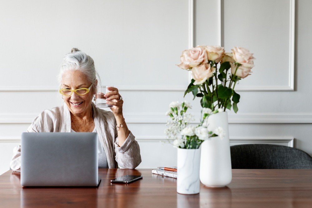 Smiling elderly lady checking her laptop